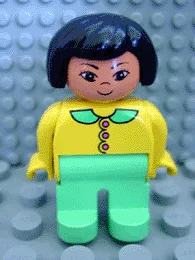 Duplo-Figur, weiblich, hellgrüne Beine, gelbe Bluse mit hellgrünem Kragen und dunkelrosa Knöpfen, schwarze Haare, Grinsen