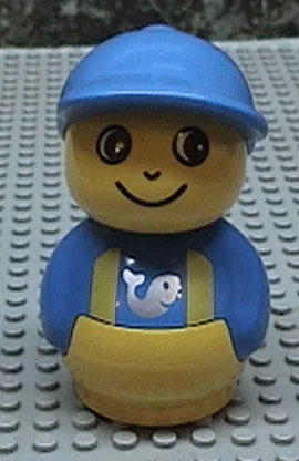 Figurine Primo Garçon avec socle jaune, haut bleu à bretelles jaunes à motifs de poissons, chapeau bleu