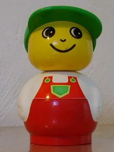 Figurine Primo Garçon avec socle rouge, haut blanc, salopette rouge à poche verte et casquette verte